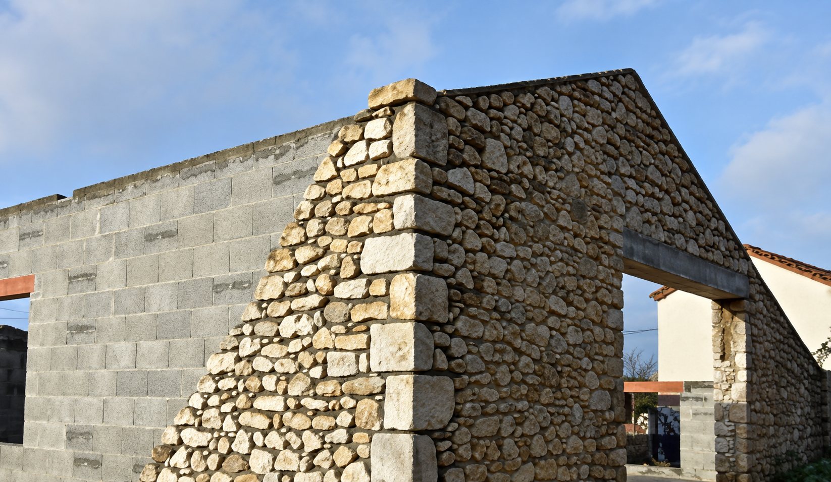 Mur de pierres et de parpaings d'une maison en construction