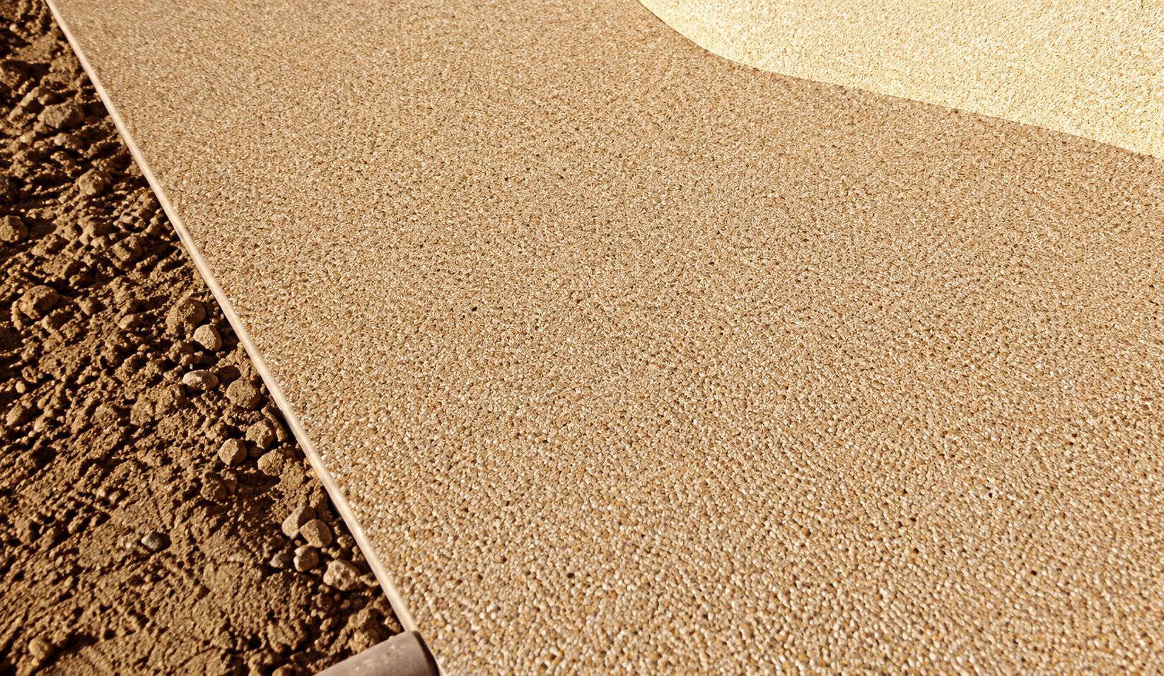 Surface en béton désactivé beige bordée de terre